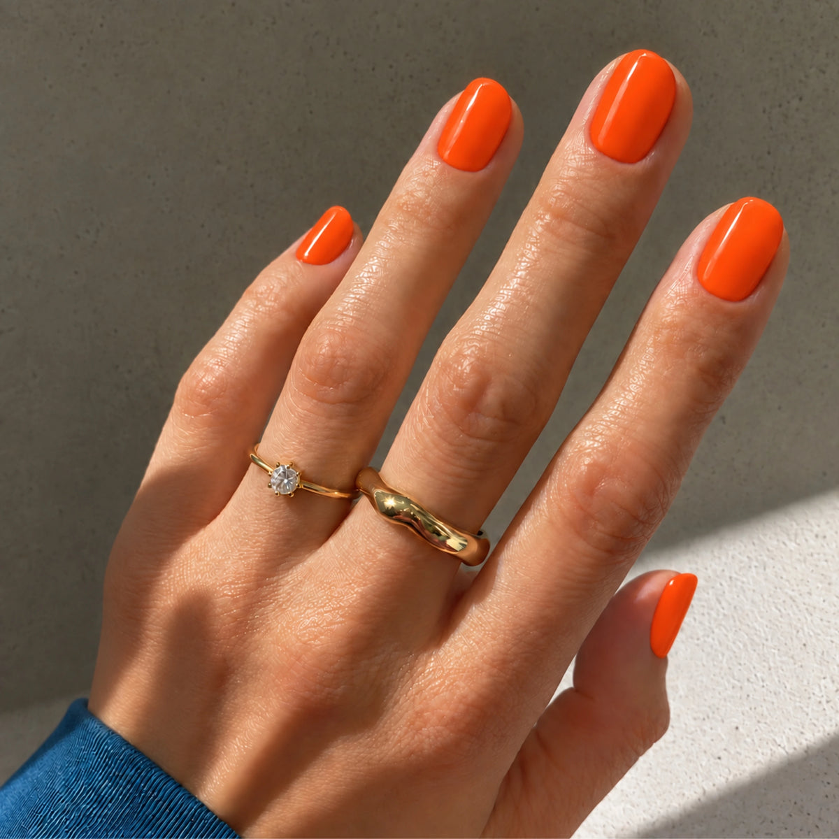 orange Naegel mit orangenen UV-Nagelfolien, Handbild Nahaufnahme von orangenen Naegeln